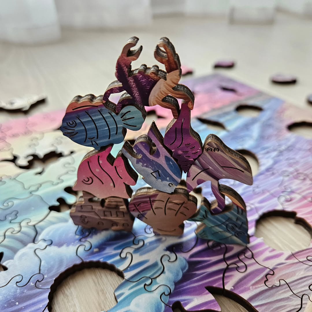 A close-up of colorful, interlocking wooden puzzle pieces shaped like sea creatures, including fish, a crab, and a pelican, stacked in a whimsical arrangement on a wavy-patterned puzzle base.